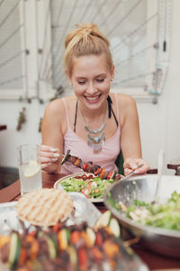 Smiling young woman having food