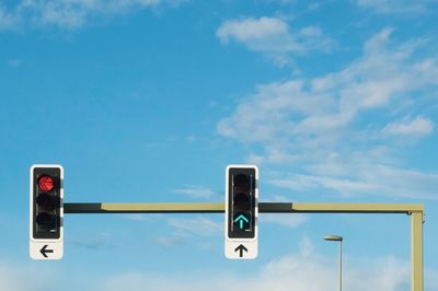 Low angle view of road signals against blue sky