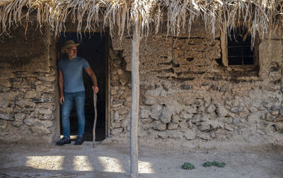 Portrait of  adult man in cowboy hat and jean in rural house