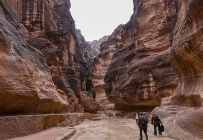 Rear view of people walking on rock