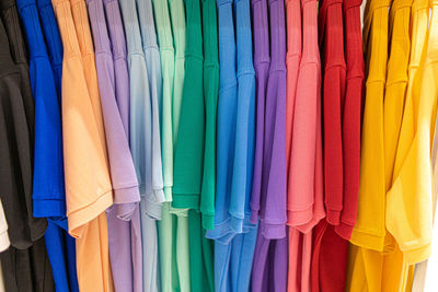 Multi colored clothes hanging on rack in store