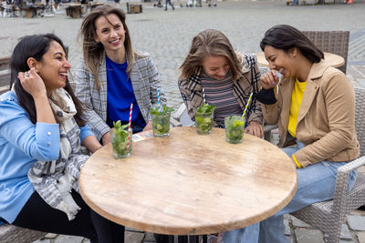 Friends toasting drinks on table