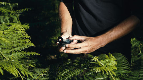 Hands of a boy opens the compass in the mountains to orient himself in the hike.