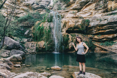Woman next to a waterfall looking at camera