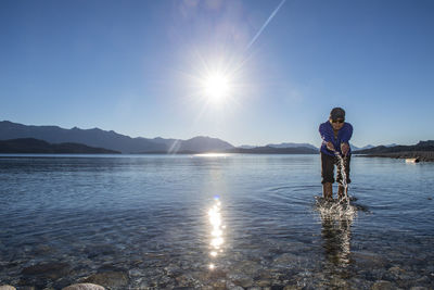 Woman trying the water at nahuel huapi lake in patagonia