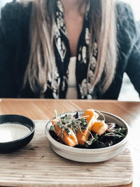 Midsection of woman eating food on table