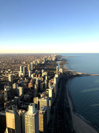 High angle view of buildings by sea against clear sky