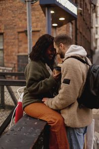 Young couple kissing near canal in town