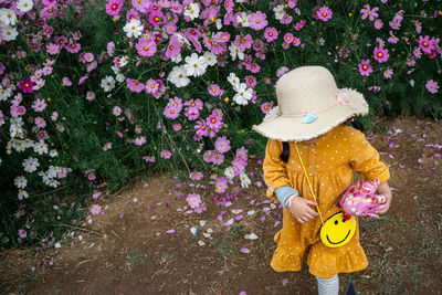 Low section of woman with pink flowers in park