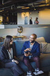 High angle view of business professionals discussing while sitting at workplace