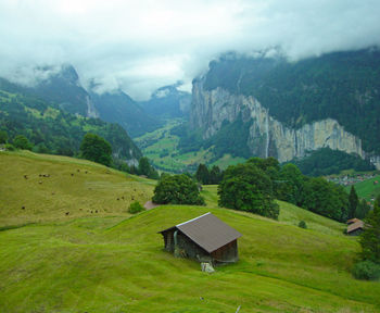 Scenic view of green landscape and mountains against sky