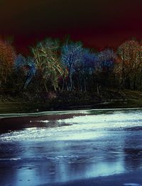 Scenic view of river by trees against sky