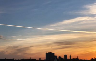 Low angle view of silhouette buildings against sky during sunset