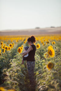 Low angle view of person standing on sunflower field