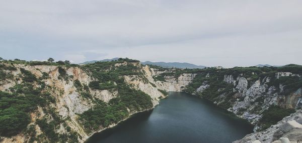 Scenic view of river amidst trees against sky