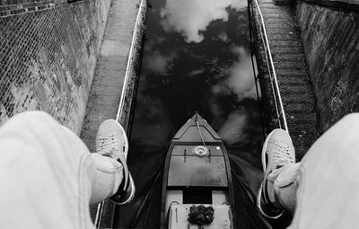 Low section of man sitting over boat in canal