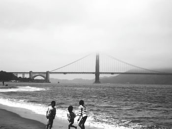 Tourists on bridge over sea