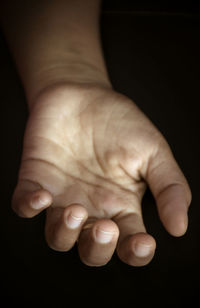 Close-up of human hand against black background