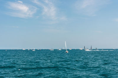 Sailboats sailing in sea against sky