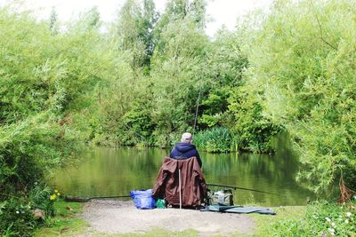 Rear view of man standing by lake