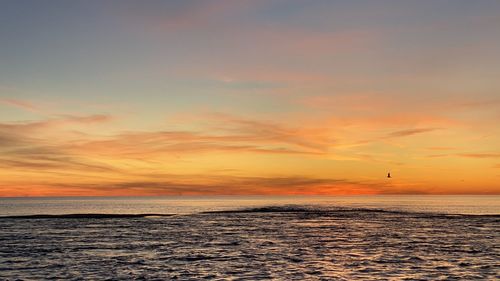 Scenic view of sea against romantic sky at sunset