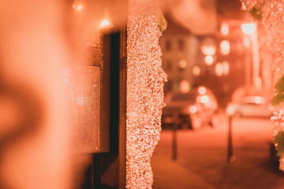 Close-up of illuminated lighting equipment hanging on street in city