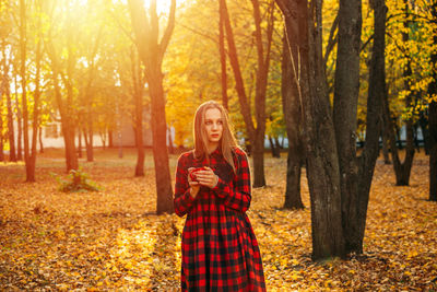 Full length of a smiling woman in autumn