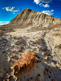 Scenic view of mountains against sky and petrified rock in the foreground.