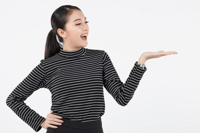 Smiling young woman looking away against white background