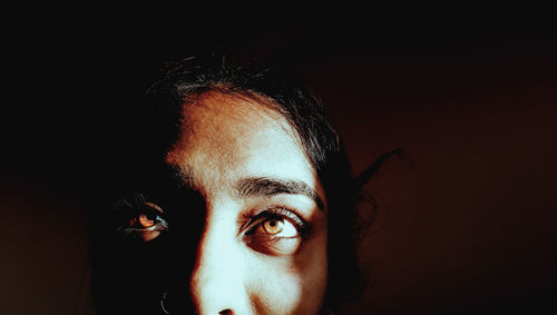 Close-up of woman face against black background