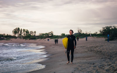 Full length of man walking on beach against sky