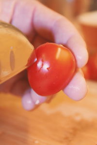 Close-up of hand cutting tomato