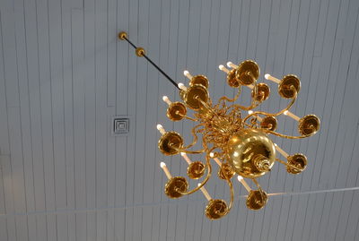 Low angle view of illuminated chandelier hanging on wall