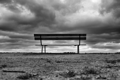 View of field against cloudy sky