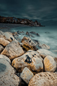 Close-up of rocks on shore against sky