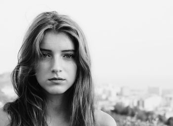 Close-up portrait of sad teenage girl against sky