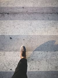 Low section of person standing on footpath