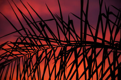 Low angle view of silhouette metal against sky during sunset