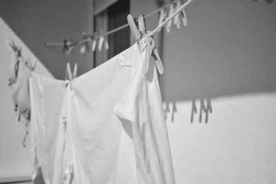 Clothes drying on clothesline against white wall