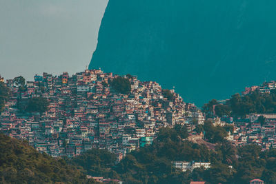 Aerial view of townscape by sea against sky