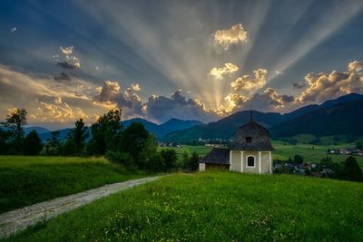 Built structure on field against sky during sunset