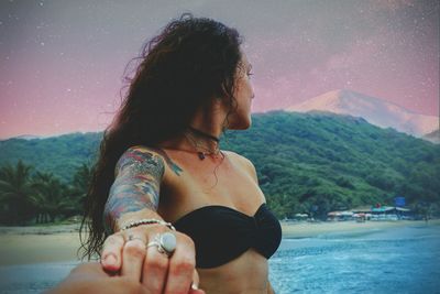 Young woman looking at mountains against sky