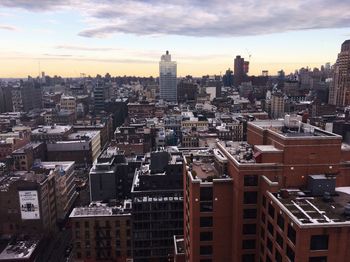 View of cityscape against cloudy sky