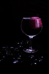 Close-up of wine glasses on table against black background