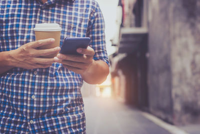 Midsection of man using mobile phone