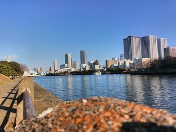 River by buildings against clear blue sky