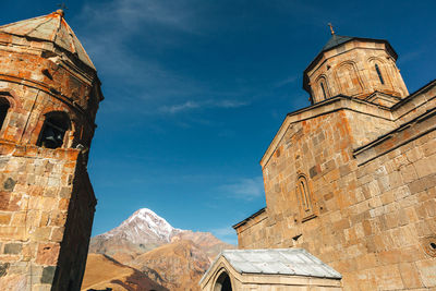 Gergeti trinity church on the mountain ridge and clouds, stepantsminda, kazbegi, georgia.