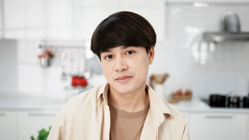 Portrait of handsome gay, attractive young gay in kitchen room.