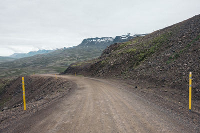 Road by mountain against sky