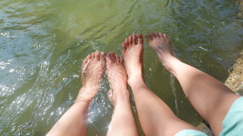 2 female legs playing in the water.